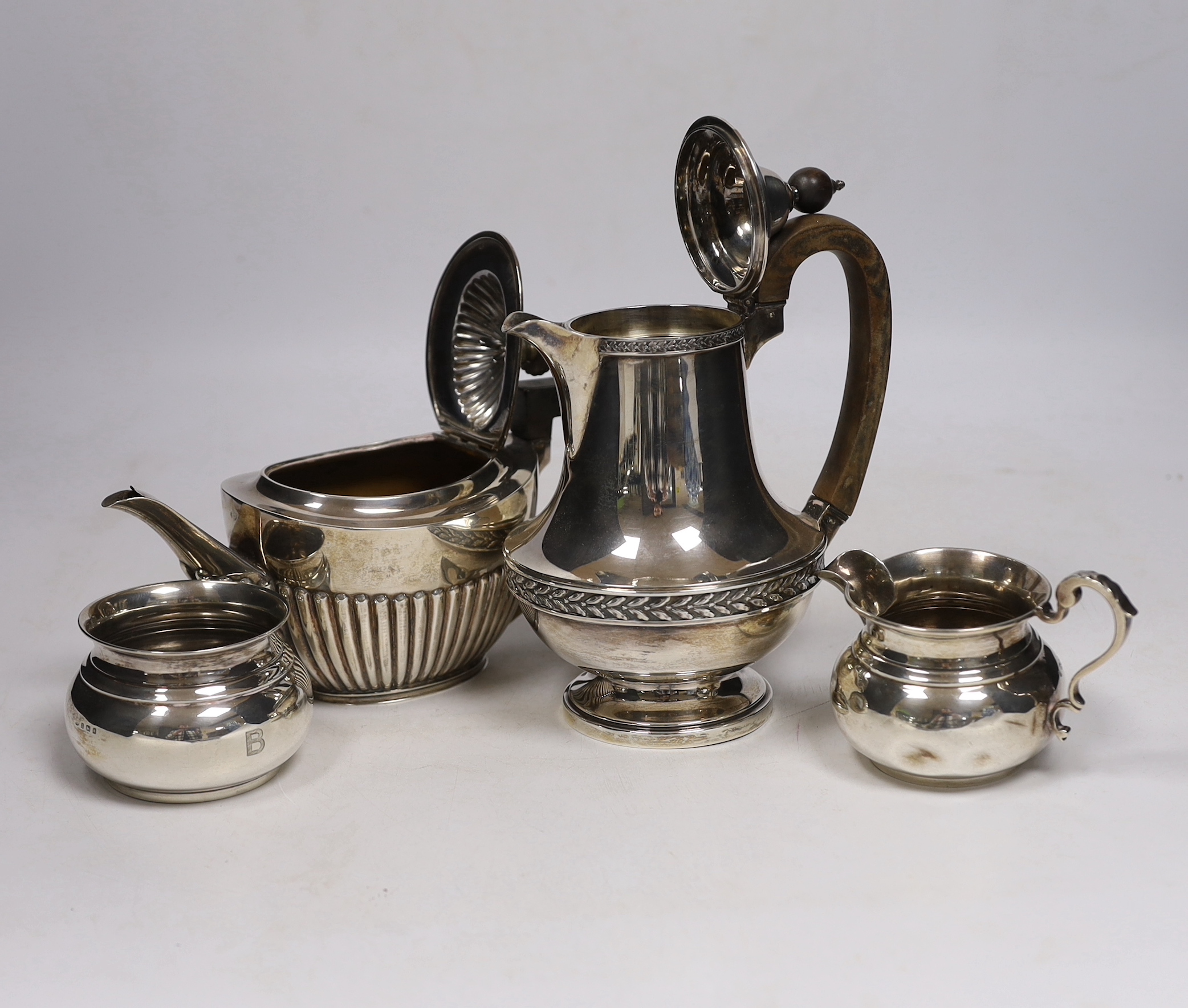 A late Victorian demi fluted silver oval teapot, John Round, Sheffield, 1897, a later silver hot water pot by Elkington & Co and a silver cream jug and sugar bowl, gross weight 28.5oz.